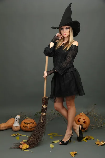 Bruja de Halloween con escoba sobre fondo gris —  Fotos de Stock