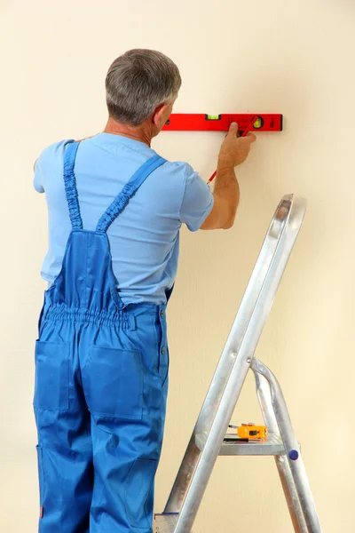 Builder mäta väggen i rummet närbild — Stockfoto