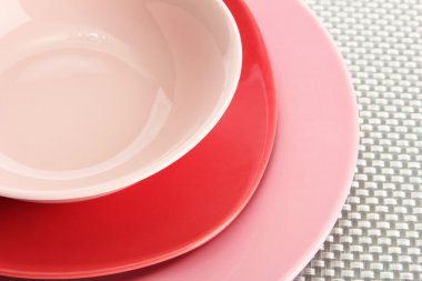 pembe boş tabak ve çanak üzerinde gri bir masa örtüsü