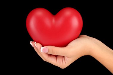 kadının el, bir arka plan siyah yakın çekim üzerinde kırmızı kalp