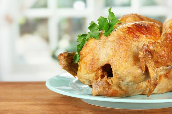 Pollo entero asado en un plato azul sobre fondo de madera de cerca — Foto de Stock