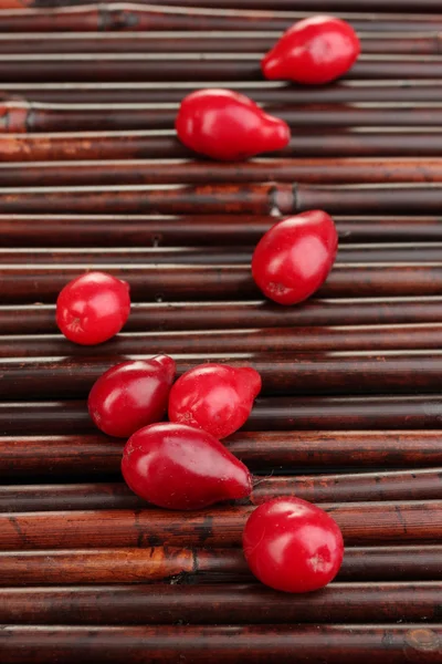 Bagas de cornel frescas na esteira de bambu — Fotografia de Stock