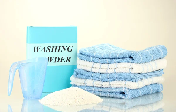 Låda med tvättmedel med blå mätning cup och handdukar, isolerad på vit — Stockfoto