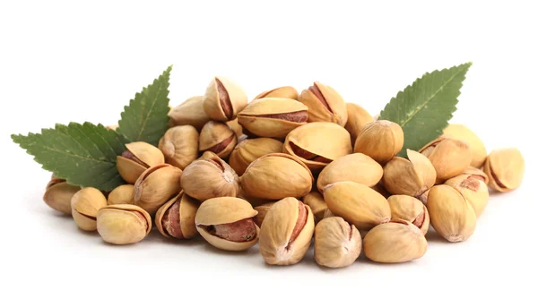 Sabrosas nueces de pistacho con hojas, aisladas en blanco —  Fotos de Stock