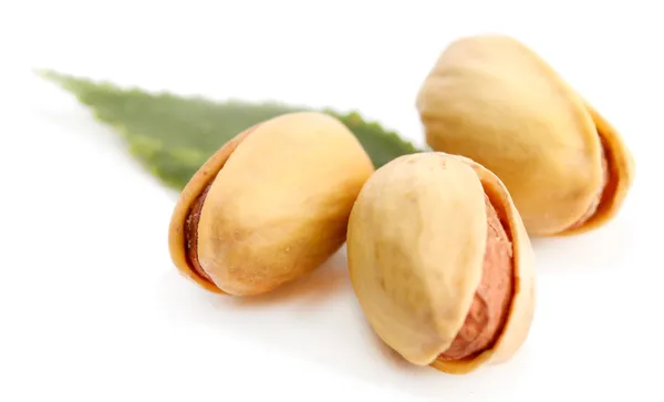 Saporiti pistacchi con foglie, isolati su bianco — Foto Stock