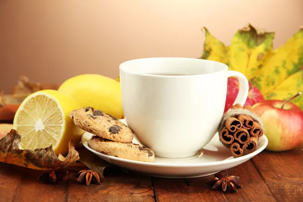Kopp varmt te och höstlöv, på brun bakgrund — Stockfoto