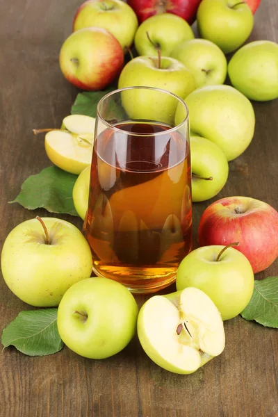 Användbara äppeljuice med äpplen runt på träbord — Stockfoto