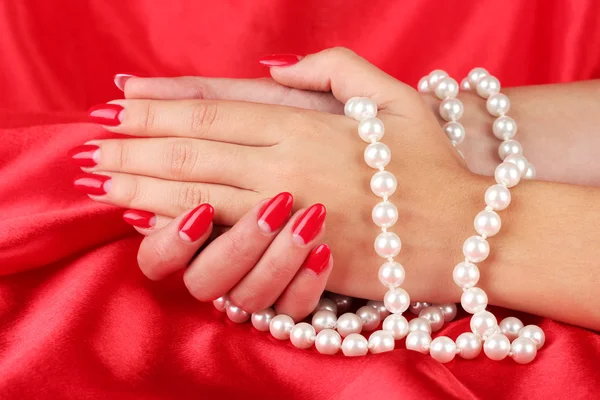 Female hands holding beads on color background Stock Photo