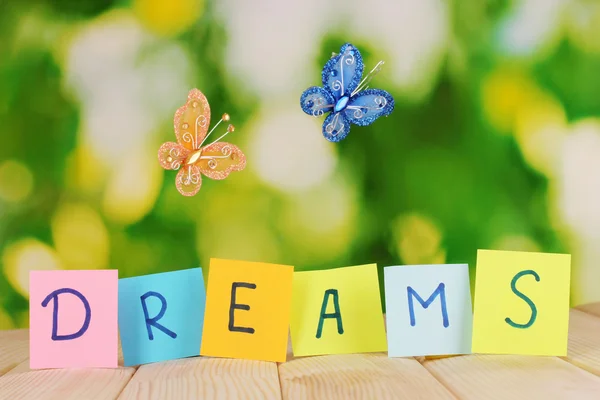 The word Dreams on wooden table on natural background — Stock Photo, Image