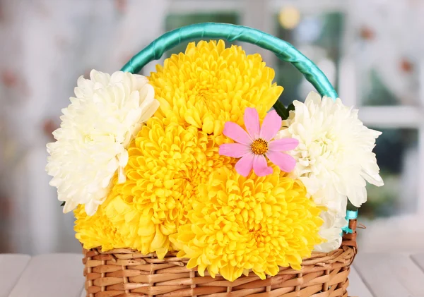 Beautiful chrysanthemum in basket on wooden table on window background — Stock Photo, Image