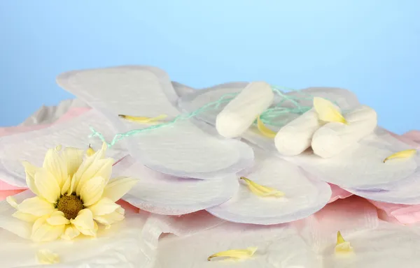 Różnych rodzajów podpasek i tamponów na niebieskim tle z bliska — Zdjęcie stockowe