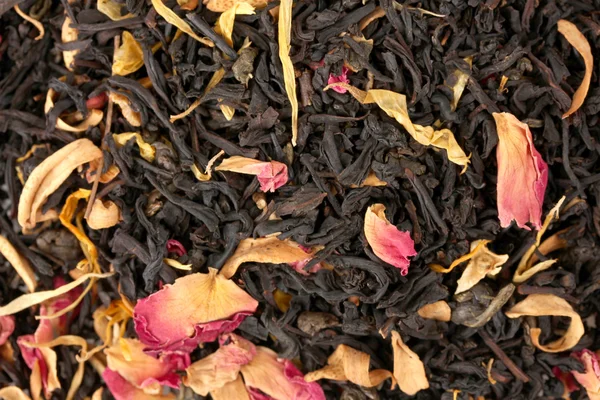 Aromatic black dry tea with fruits and petals, close up — Stock Photo, Image