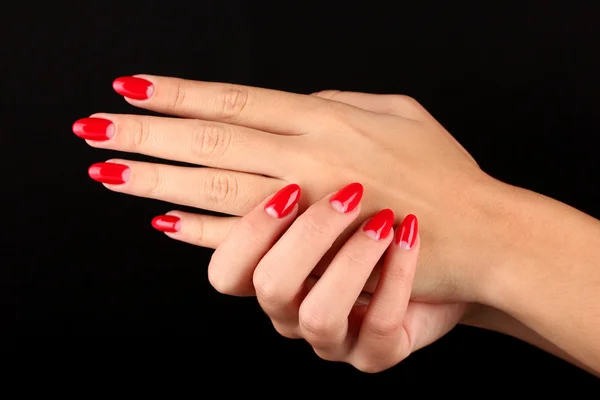 Beautiful female hands with red nails isolated on black — Stock Photo, Image