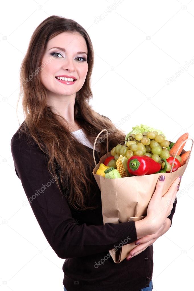 Woman holding a grocery bag full of fresh vegetables and fruits isolated on white