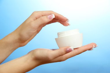 krem, mavi zemin üzerine ile güzel bir kadın el