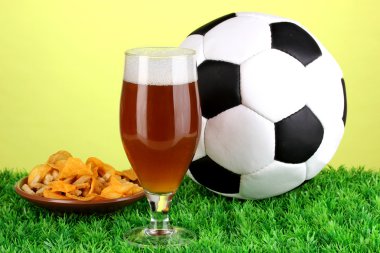 bardak bira ile çim yeşil zemin üzerine futbol topu