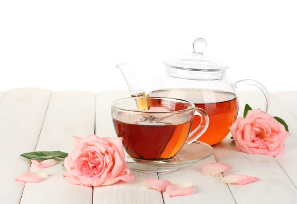 Tekanna och kopp te med rosor på vit träbord — Stockfoto