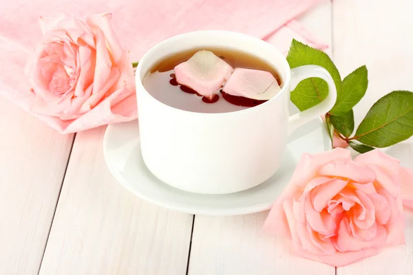 Cup of tea with roses on white wooden table — Stock Photo, Image