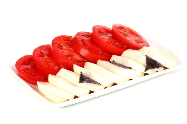 Smakelijke mozzarella met tomaten op plaat geïsoleerd op wit — Stockfoto