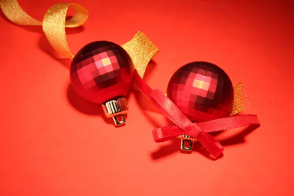 Vackra ljusa julgranskulor på röd bakgrund — Stockfoto