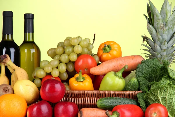 Kompozycja z warzyw i owoców w wiklinowym koszu na zielonym tle — Zdjęcie stockowe