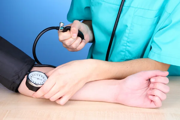 Medición de la presión arterial sobre fondo azul — Foto de Stock