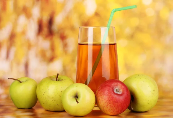 Jugo de manzana útil con manzanas alrededor en el fondo de otoño — Foto de Stock