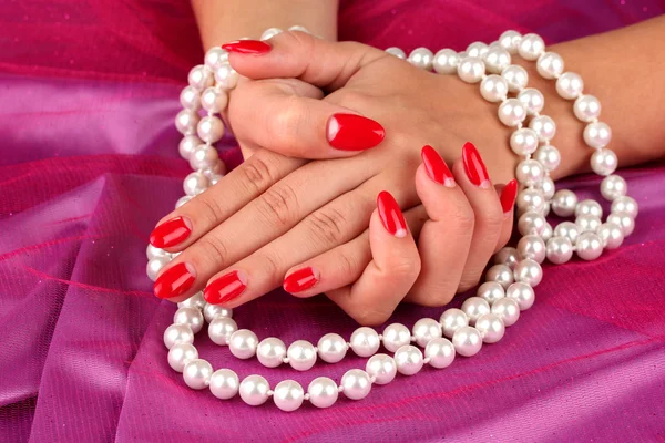 女手控股珠子颜色背景上 免版税图库照片