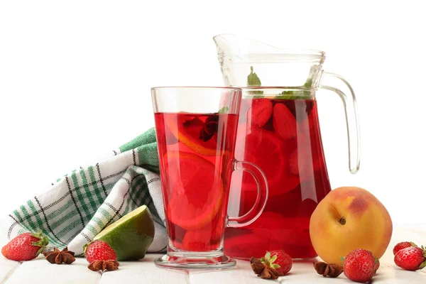 Sangria in jar and glass with fruits, on white wooden table, isolated on white — Stock Photo, Image