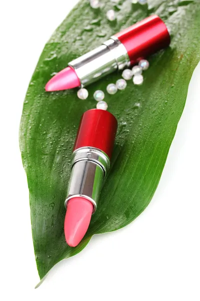 Lipsticks on green leaf isolated on white — Stock Photo, Image