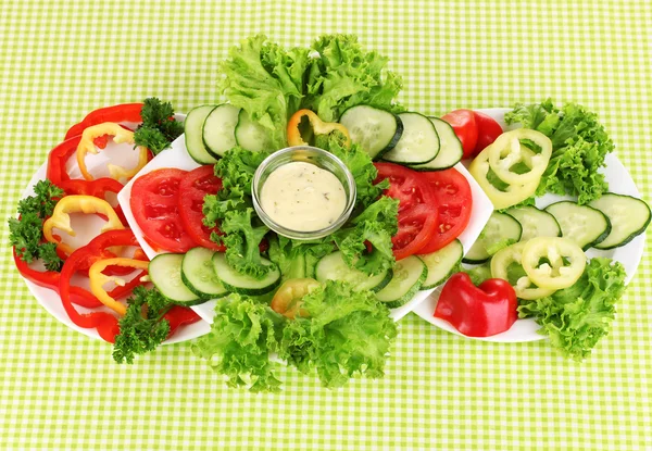 Verduras picadas y salsa en plato sobre mantel verde — Foto de Stock