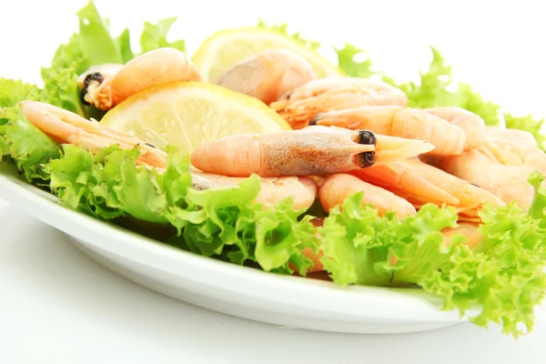 Boiled shrimps with lemon and lettuce leaves on plate, isolated on white — Stock Photo, Image