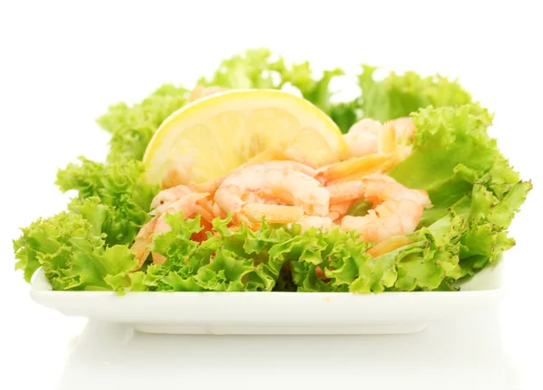 Варені креветки з лимоном і листям салату на тарілці, ізольовані на білому — стокове фото