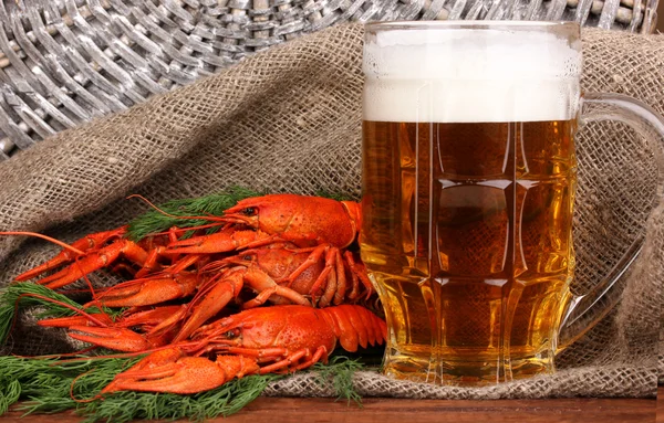 Sabroso cangrejos de río hervidos y cerveza en la mesa sobre fondo de saco —  Fotos de Stock