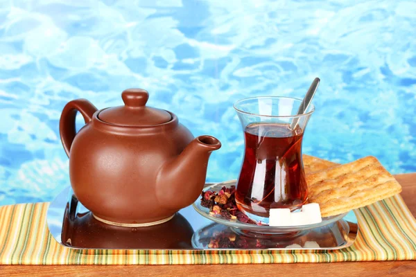 Vidro de chá turco e chaleira no fundo de cor — Fotografia de Stock
