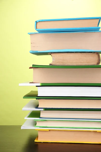 Stapel interessanter Bücher und Zeitschriften auf Holztisch auf grünem Hintergrund — Stockfoto