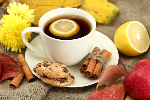 Taza de té caliente y hojas de otoño, sobre fondo de arpillera —  Fotos de Stock