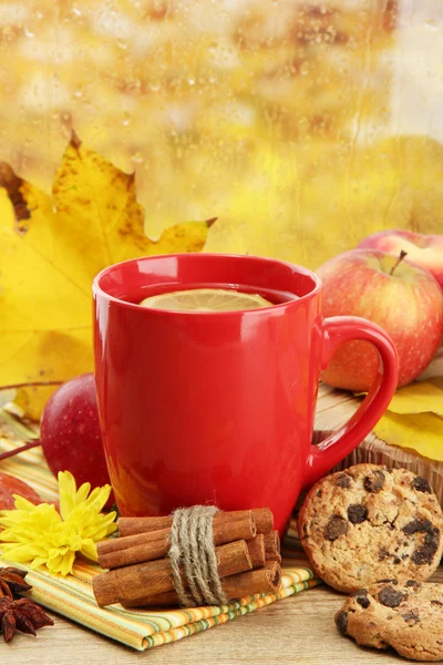 Tasse de thé chaud et feuilles d'automne, sur fond de pluie — Photo