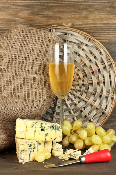 Samenstelling van blauwe kaas en een glas wijn met druiven op houten achtergrond close-up — Stockfoto