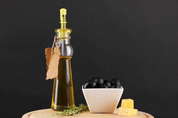 Olive nere in ciotola bianca con rosmarino, olio e formaggio a bordo isolate su nero — Foto Stock