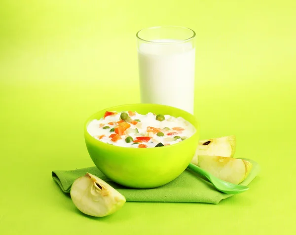 Tasty dieting food and glass of milk, on green background — Stock Photo, Image