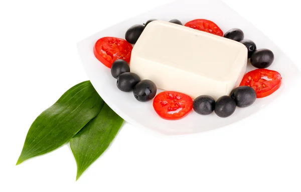 Fetaost på plattan dekorerad med oliver och tomater isolerad på vit — Stockfoto