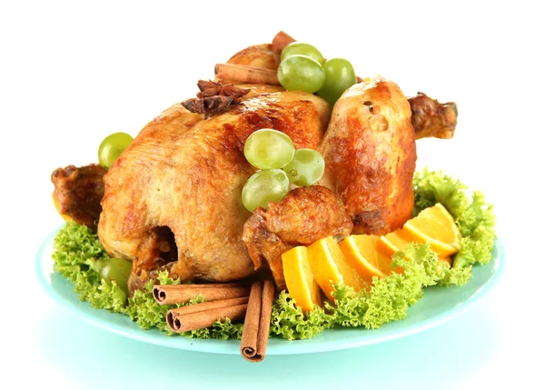 Whole roasted chicken with lettuce, grapes, oranges and spices on blue plate isolated on white — Stock Photo, Image