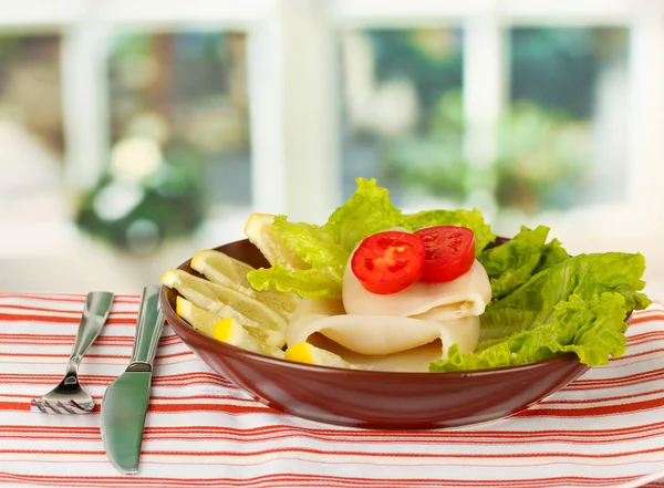 Calmars bouillis avec des légumes dans l'assiette sur la nappe gros plan — Photo