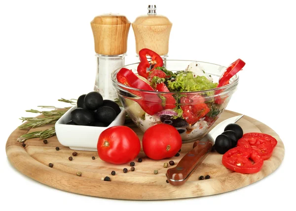 Fresh greek salad in glass bowl surrounded by ingredients for cooking isolated on white — Stock Photo, Image