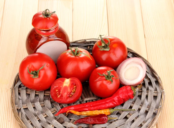 Ketchup y tomates maduros sobre mesa de madera — Foto de Stock