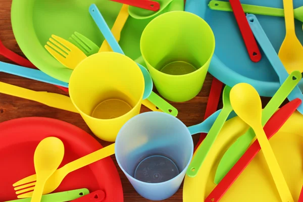 Plástico brilhante utensílios de mesa descartáveis em fundo de madeira close-up — Fotografia de Stock