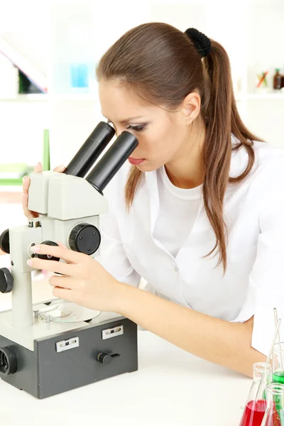 Unga forskare undersöker mikroskopet i laboratorium — Stockfoto