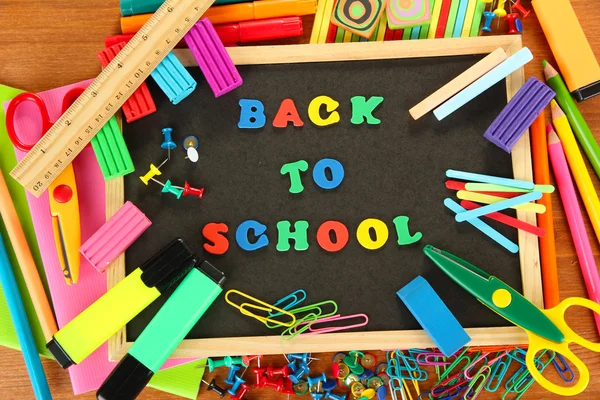 Petit tableau avec fournitures scolaires sur fond bois. Retour à l'école — Photo