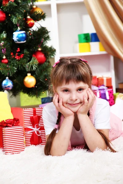 Menina perto da árvore de Natal no quarto festivamente decorado — Fotografia de Stock